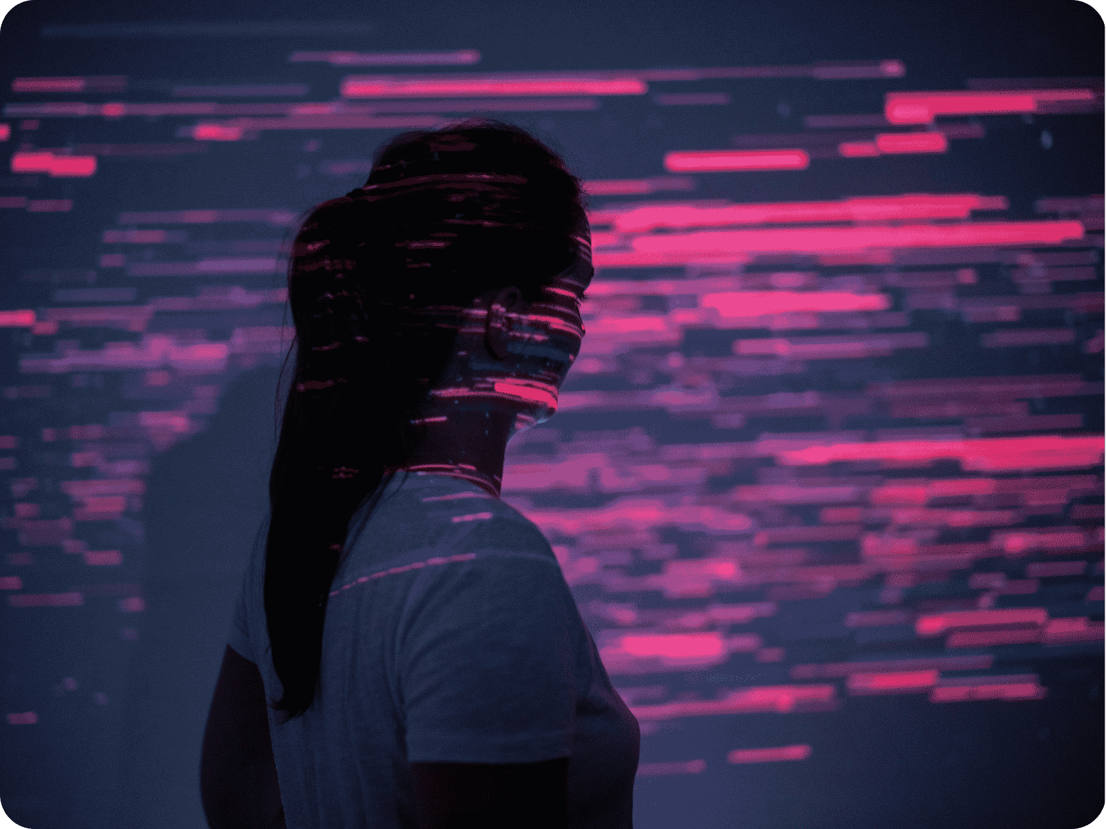 Woman silhouetted before a wall of streaming agentic AI data visualizations in pink and red, representing humans navigating an agentic AI-powered world.