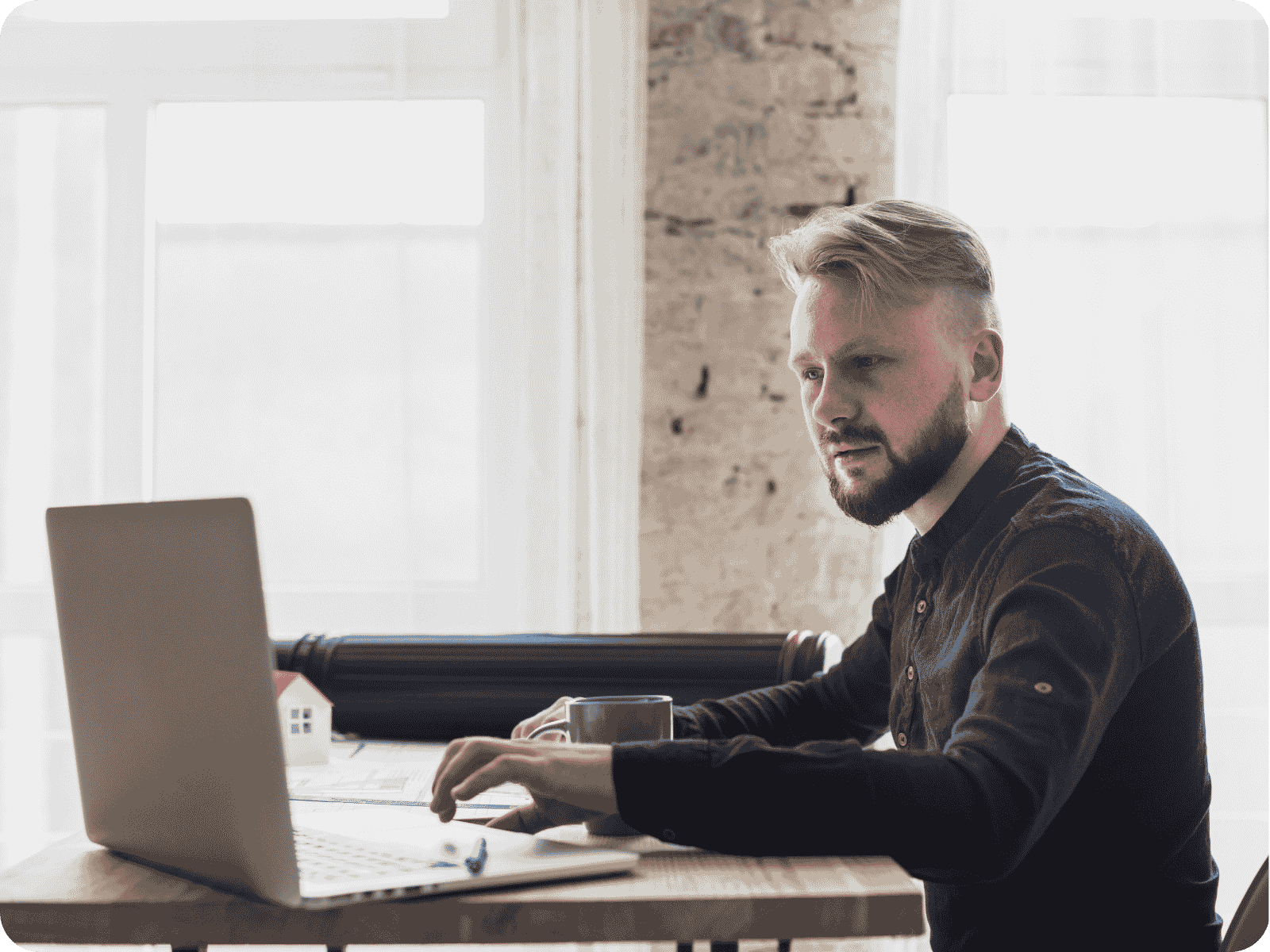 A field service business owner reviews his operations schedule on a laptop at his desk.