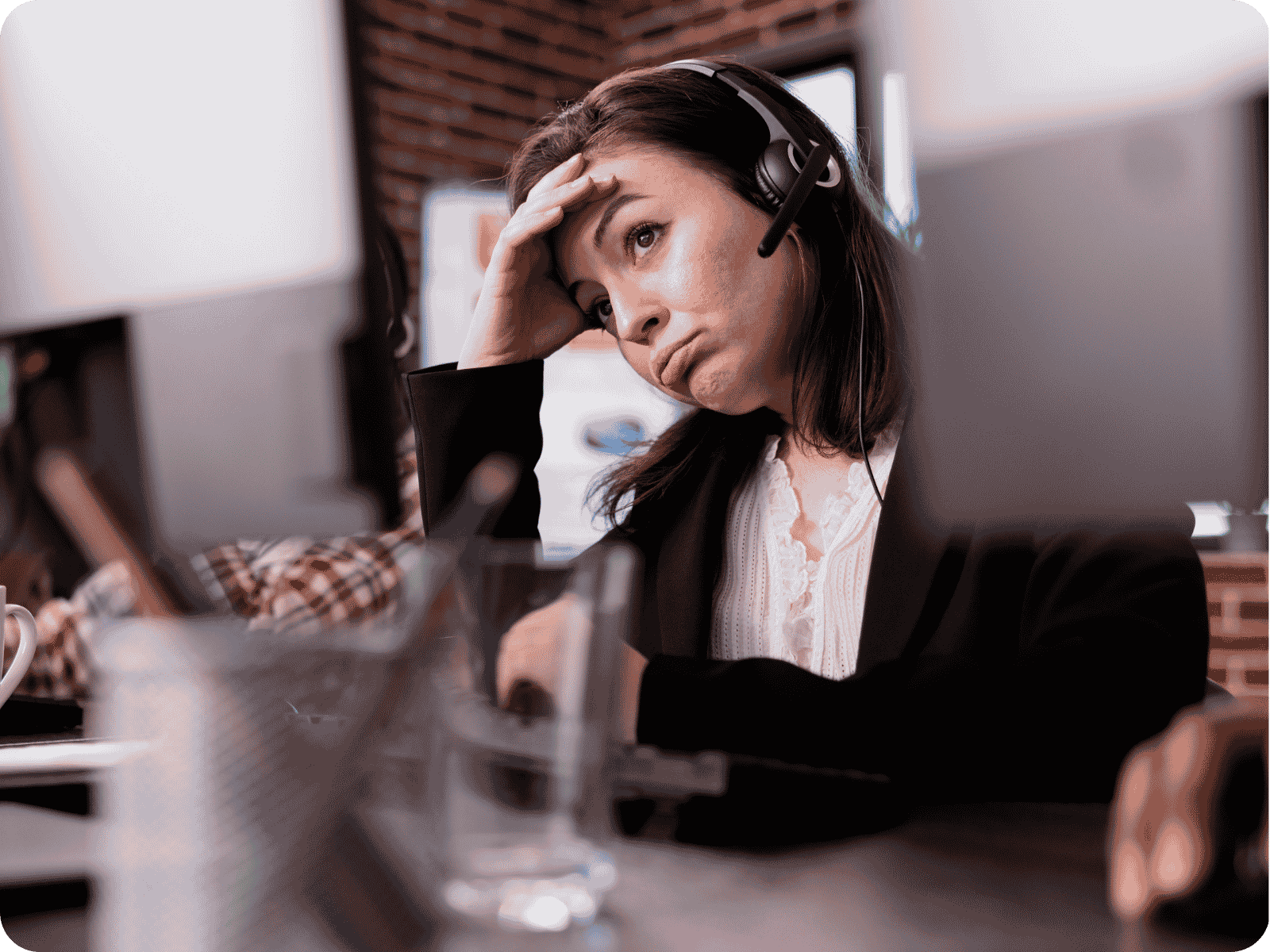 Overwhelmed field service dispatcher struggling with scheduling problems at her desk