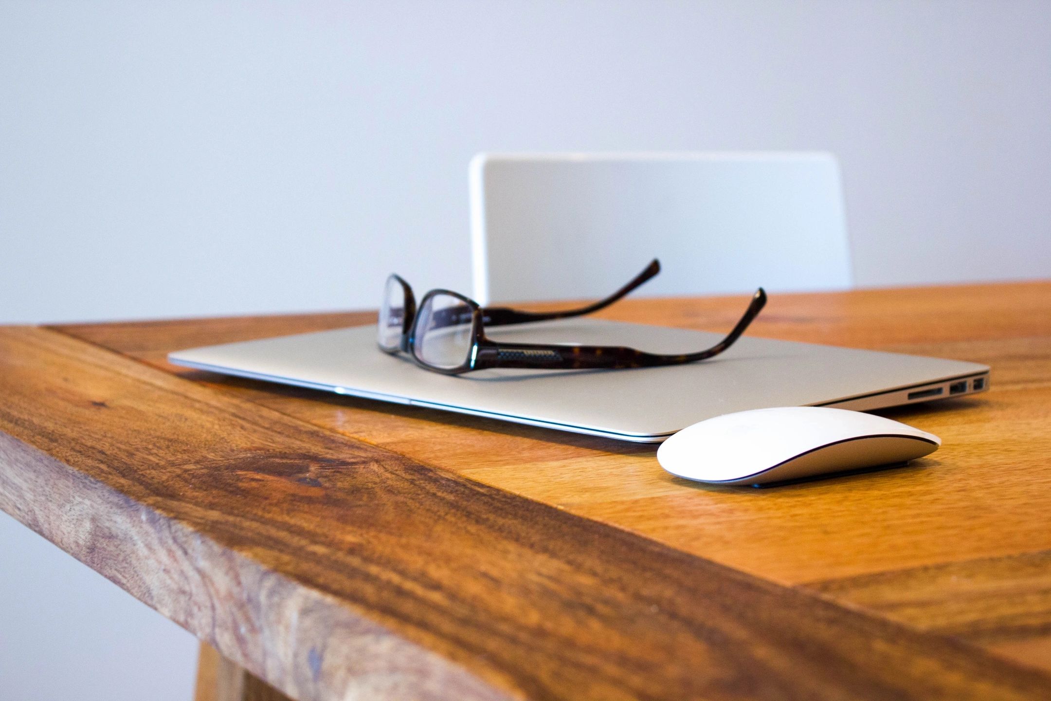 glasses over a mac on wooden table