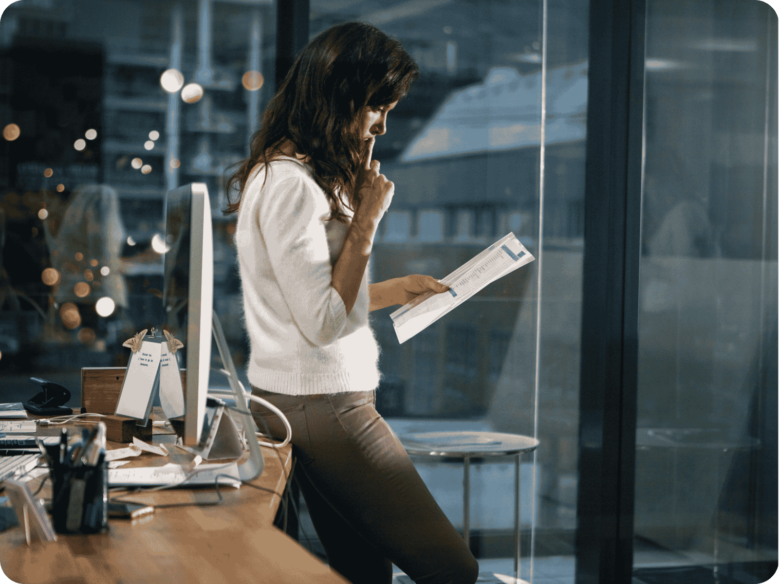 Businesswoman reviewing a printed report while researching field service software requirements at her office desk
