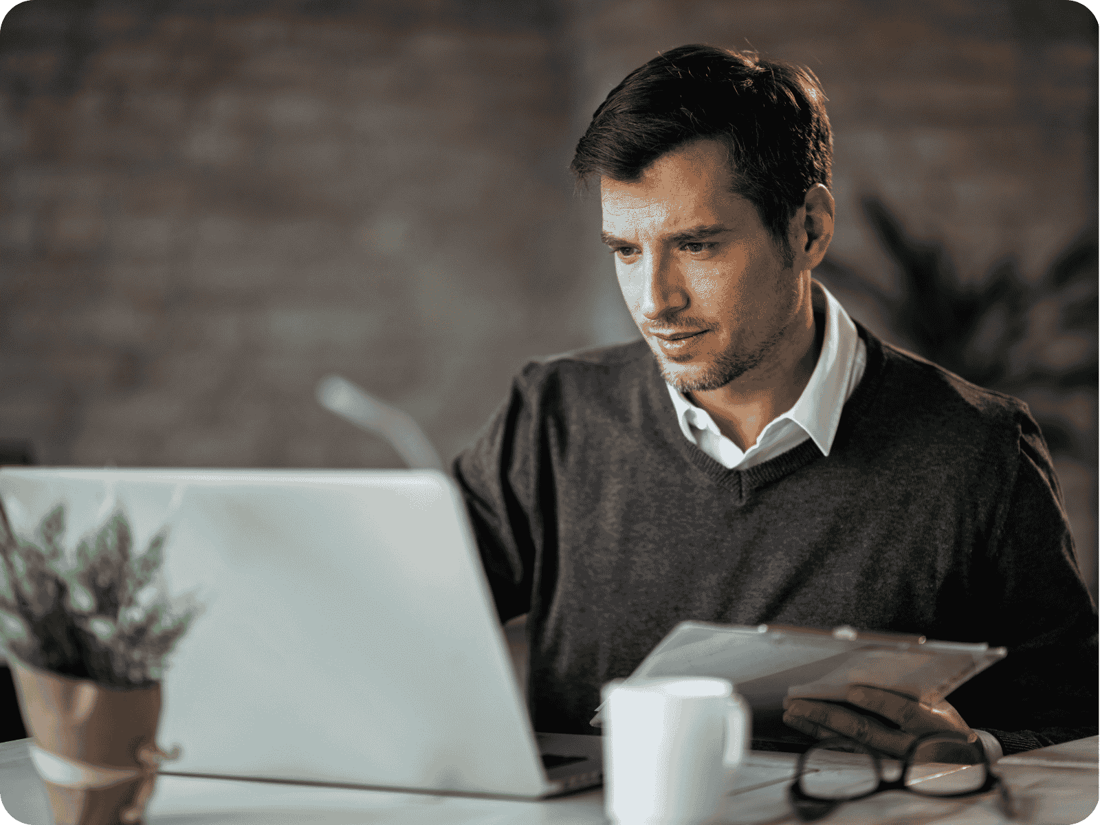 Man reviewing custom field service software cost estimates on a laptop